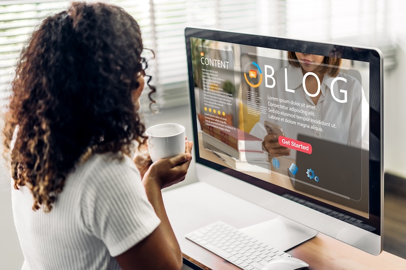 A woman looking at a blog on her desktop computer.